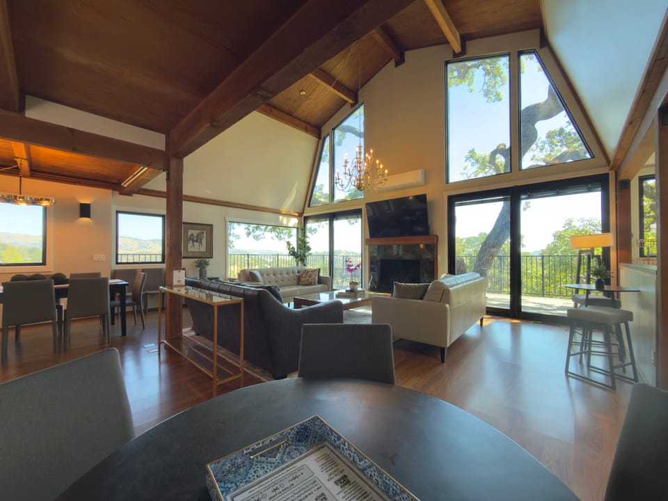 Great room at Marin Vista Retreat — fireplace, high ceiling, and chandelier, San Rafael